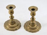 pair of antique brass candlesticks on a white background