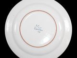 a close up of a plate with writing on it on a black surface