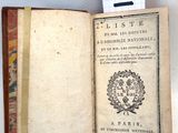 un livre ouvert, muni d'une étiquette, posé sur une table