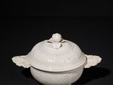 a white bowl with a lid on a black surface