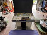 une console de jeux vidéo posée dans un garage à côté d'un skateboard