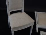 a white chair and a chair with a white cushion on it