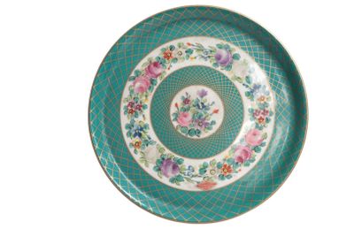 a green plate with flowers on it on a white background