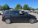 the black volkswagen touran is parked in a parking lot