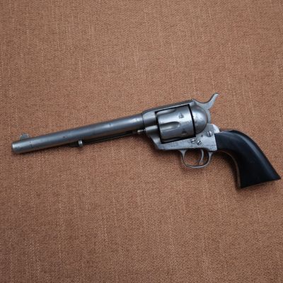 a revolver with a wooden handle on a brown background