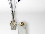 a vase with flowers in it next to a vase with gold decorations