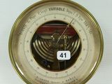une horloge accrochée au mur, à laquelle est fixé un baromètre