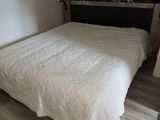 a bed with a white comforter in a small room