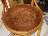 a wooden chair with a carved design on the seat