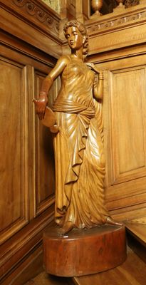 une statue représentant une femme debout sur un socle dans une pièce