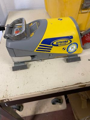 a yellow and gray machine sitting on a table next to a yellow bucket