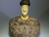 a ceramic sculpture of a man with a hat on his head
