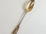 a silver spoon on a white surface with a silver handle