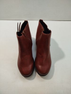 bottines en cuir marron avec des fermetures éclair sur un fond blanc