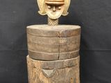 a wooden box with a carved head on top of it