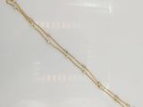 a close up of a gold necklace on a white surface