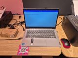 un ordinateur portable posé sur un bureau en bois, avec une souris à côté
