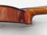 the back end of a violin with a bow on a white surface