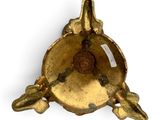 an image of a gold plate with a bird on top of it