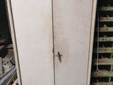an old refrigerator in the middle of a dirty room