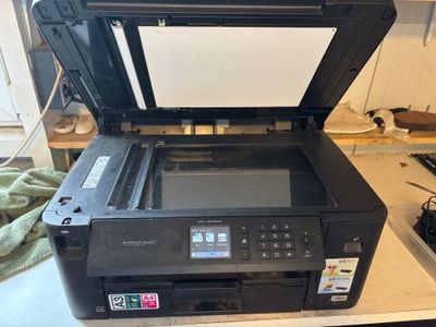 L'imprimante est posée sur le bureau, à côté de l'ordinateur.