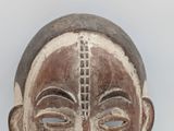 a close up of a wooden mask on a table