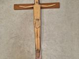 une croix en bois posée par terre, sur laquelle se trouve un homme