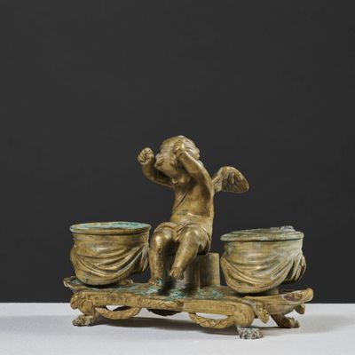 bronze figurine of a boy on a sleigh with two bowls