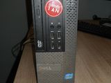 un ordinateur posé sur un bureau, avec un ventilateur dessus