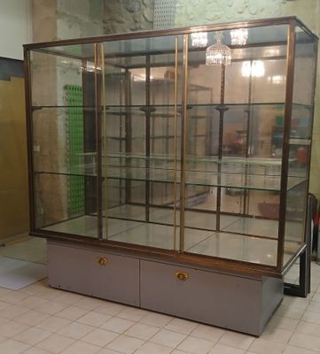 a glass display case in the middle of a tiled floor