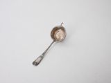 silver spoon on a white surface with a small spoon in the middle of it