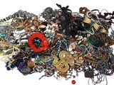 a pile of assorted jewelry on a white surface