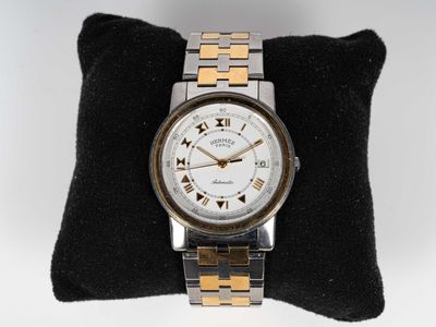 HERMÈS. Montre bracelet "Carrick" en or et acier. Boîtier circulaire e