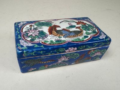 une boîte bleue avec l'image d'un dragon et des fleurs dessus