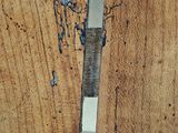 a close up of a piece of wood with a knife sticking out of it