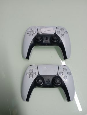 two video game controllers sitting next to each other on a table