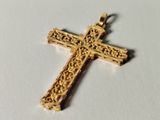 gold plated cross pendant with filigree design on a white background