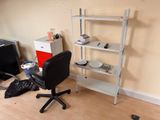 a desk with a chair and a computer on it in a room