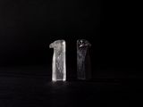 deux morceaux de verre posés sur une table, sur fond noir