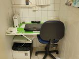 a desk with a chair and a printer in a small room