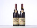 two bottles of red wine sitting on top of a table