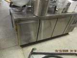stainless steel counter top with pots and pans on it in a commercial kitchen
