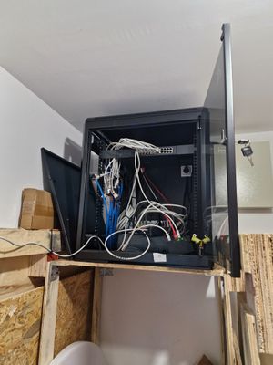 une armoire informatique sur laquelle sont posés tout un tas de câbles