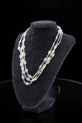 a close up of a necklace on a mannequin with a black background