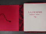 un livre ouvert, à la couverture rouge, posé sur une table