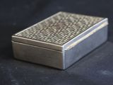 a silver box that is sitting on a black surface
