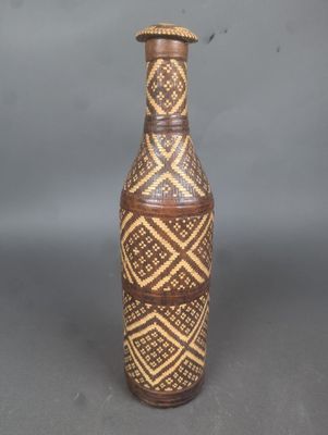 un vase marron orné d'un motif, posé sur une table