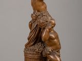 bronze statue of a woman with a basket of grapes on a table
