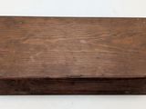 an old wooden box is sitting on a white surface