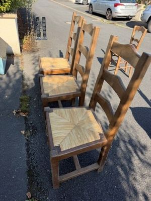 quatre chaises en bois posées au bord de la rue